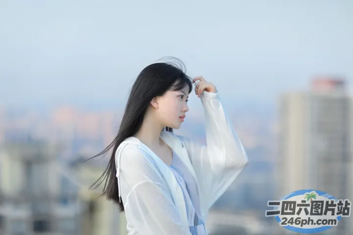 有一个女人站在窗台上，背景是一座城市