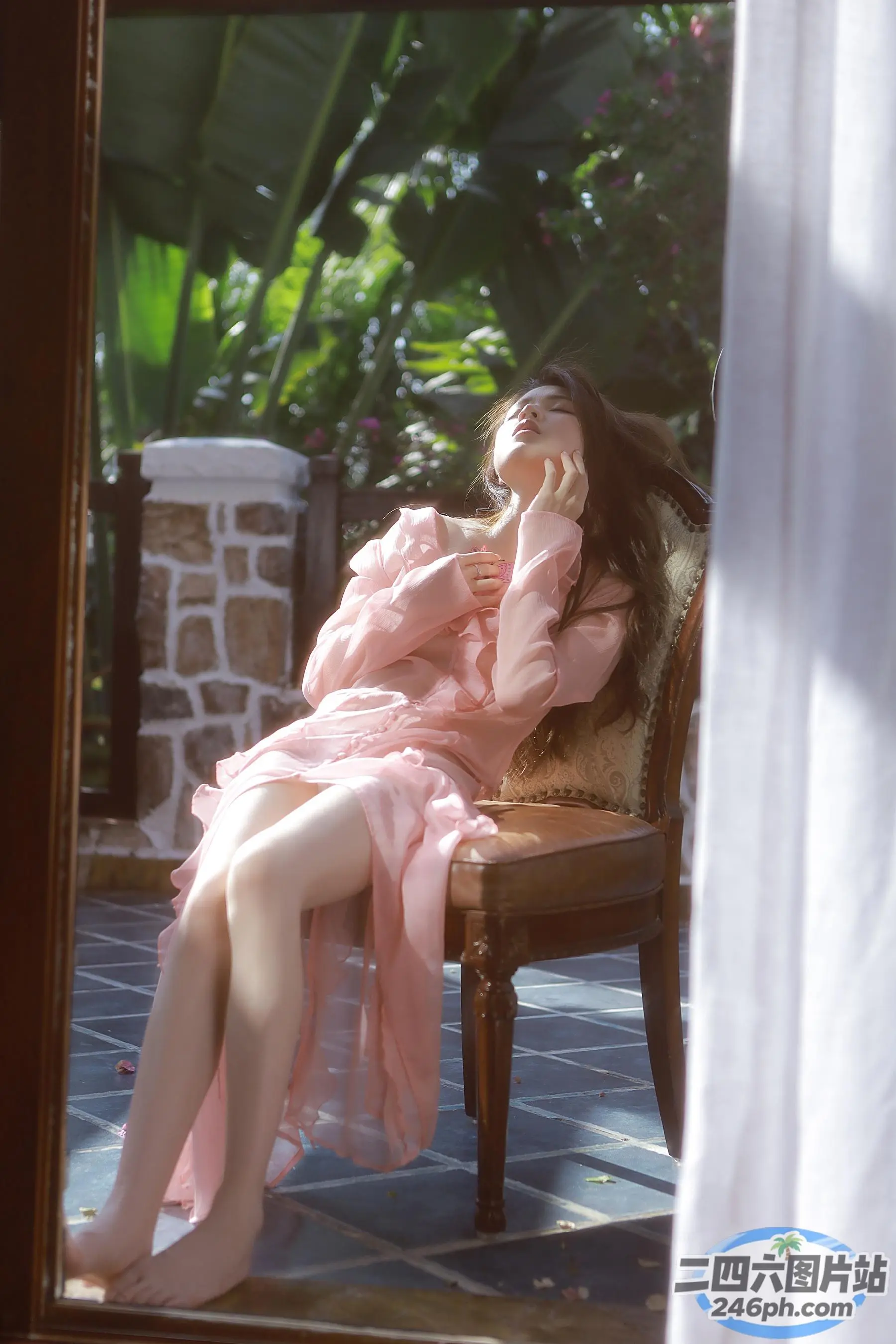 坐在椅子上、身穿粉红色连衣裙的 Arafed 女子