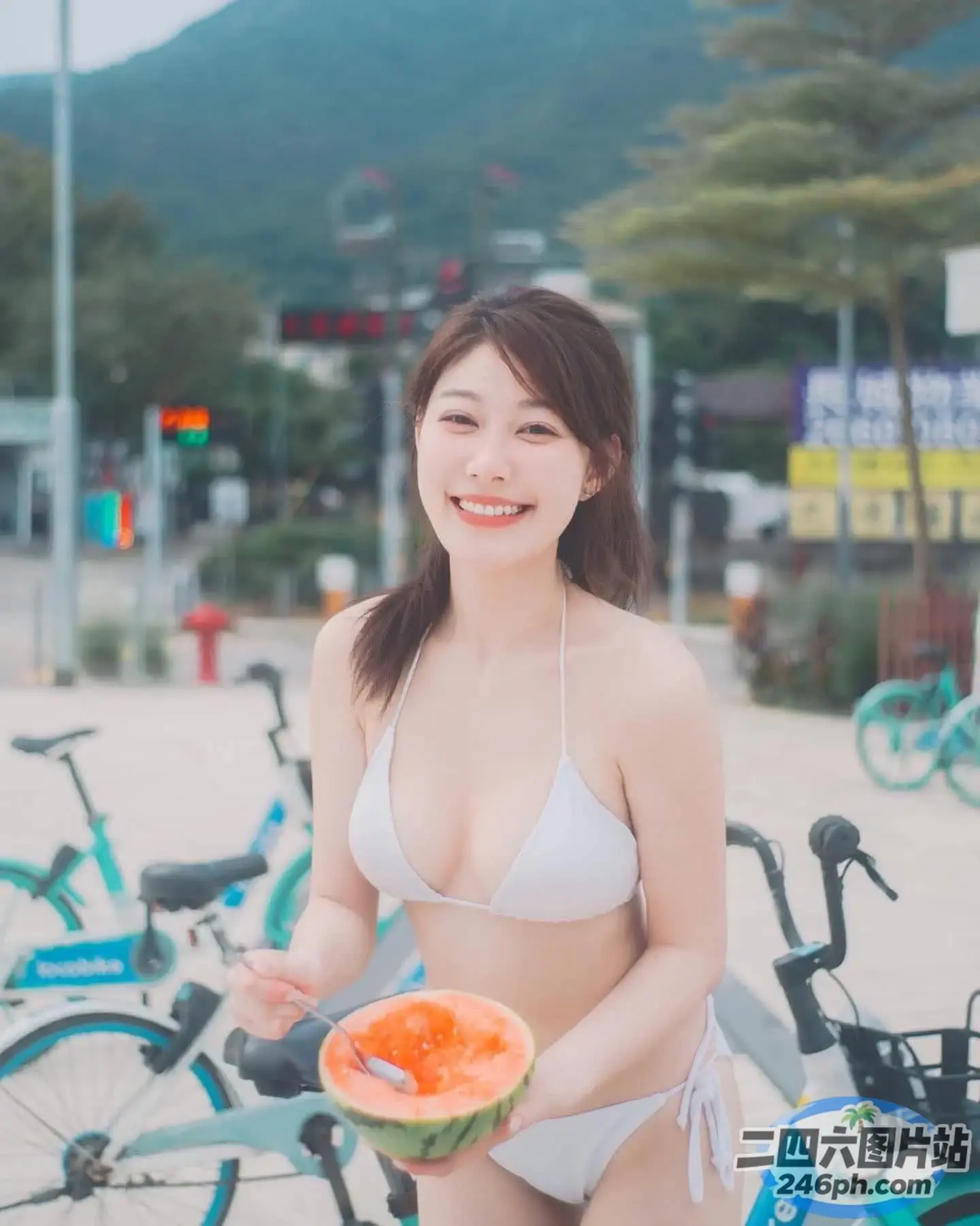 穿着比基尼的 arafed 亚洲女子，手里拿着西瓜