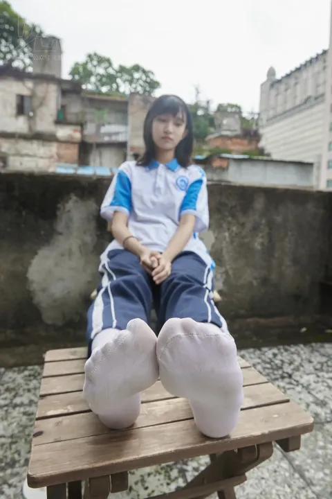 有个女人坐在长凳上，双脚抬起