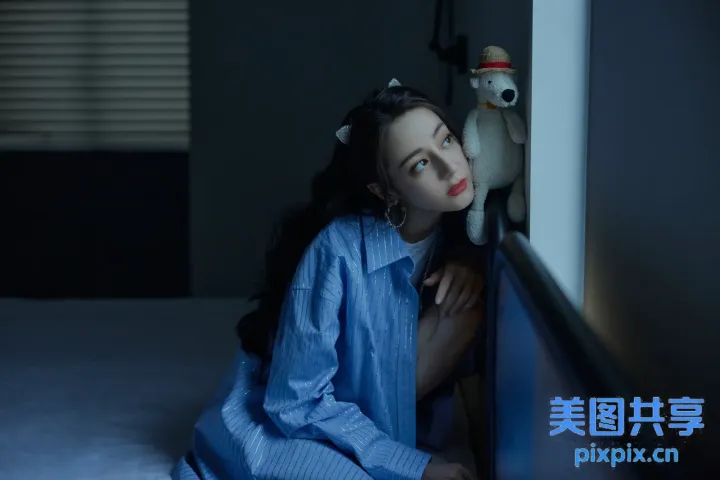 有一个女人坐在床上，有一个毛绒玩具