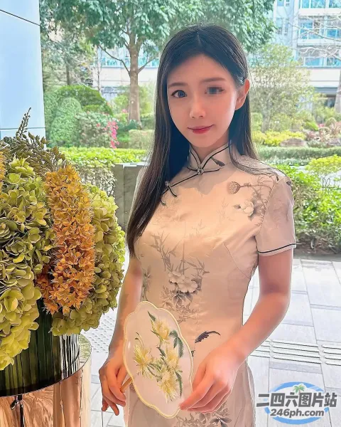 有一个女人站在一瓶花瓶旁边