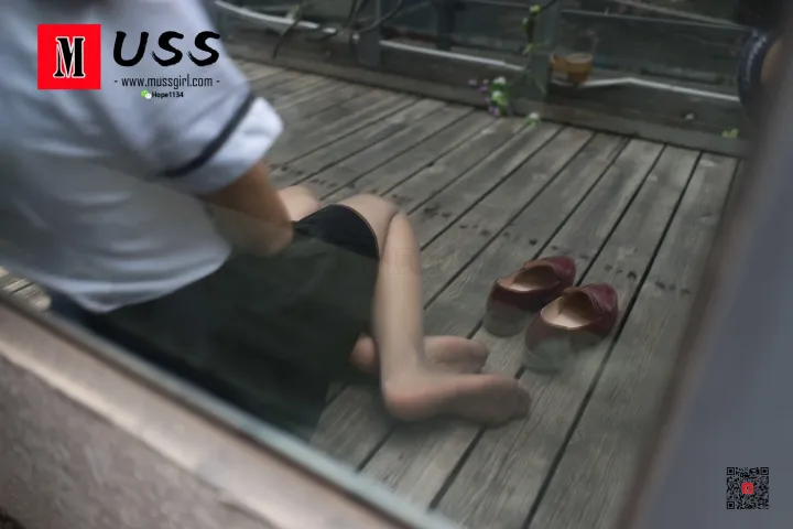 有一个男人坐在甲板上，双脚抬起