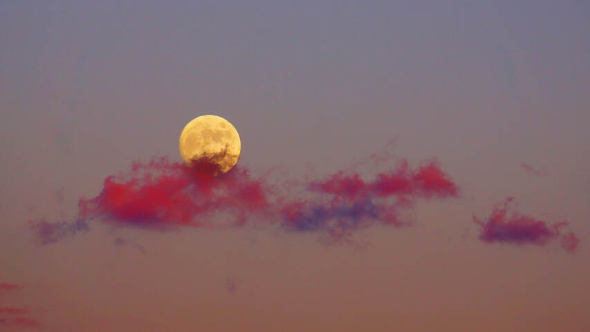 满月从云雾缭绕的天空中升起的美景
