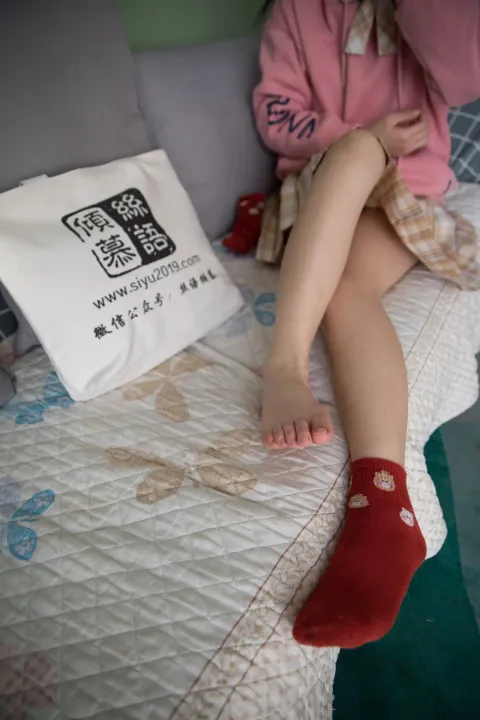 有一个小女孩坐在床上，枕头