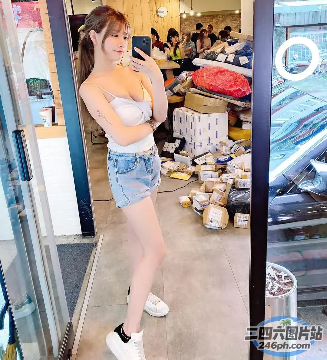 有个女人站在商店里看手机