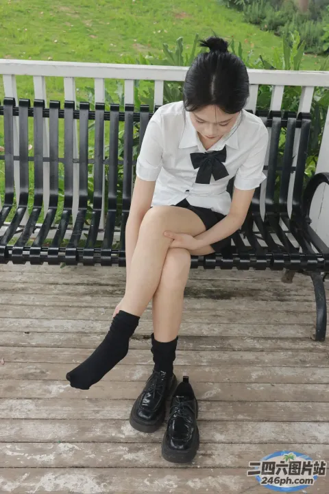 有个女人坐在长凳上，双腿交叉