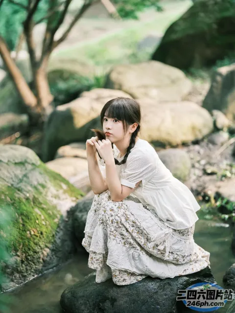 有个女人跪在溪流的一块石头上