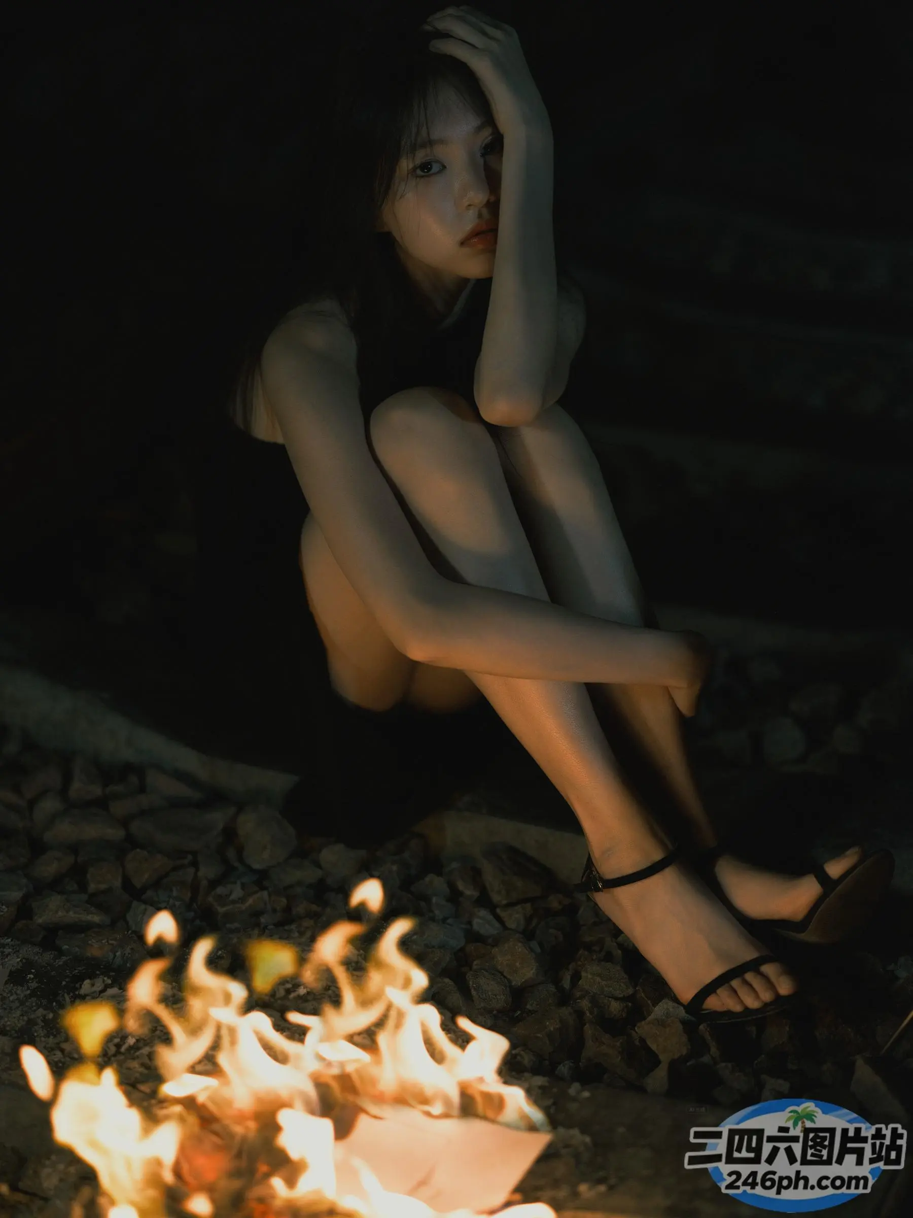 坐在火堆旁地上的阿拉菲德妇女