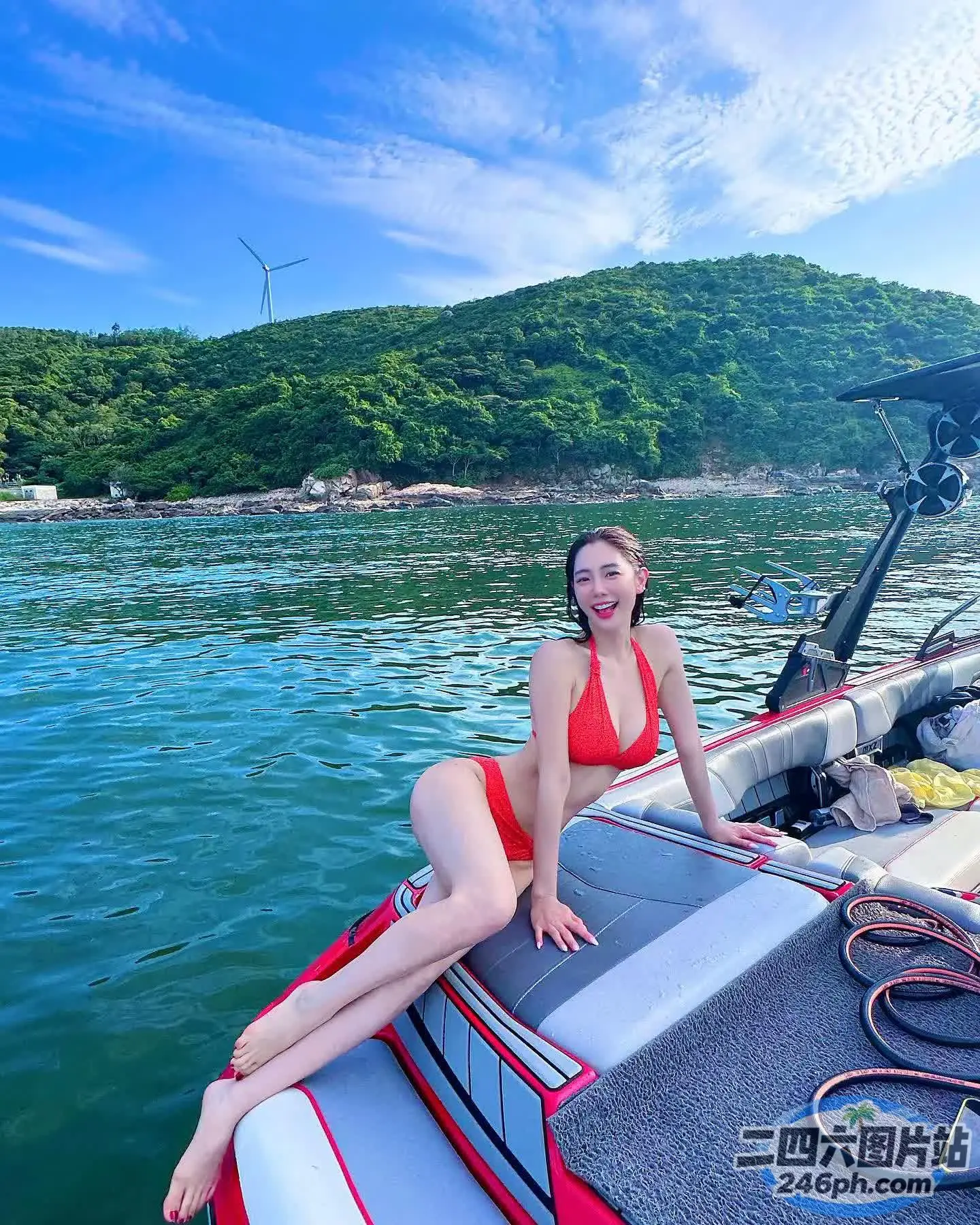 身穿红色比基尼的女人坐在水中的船上