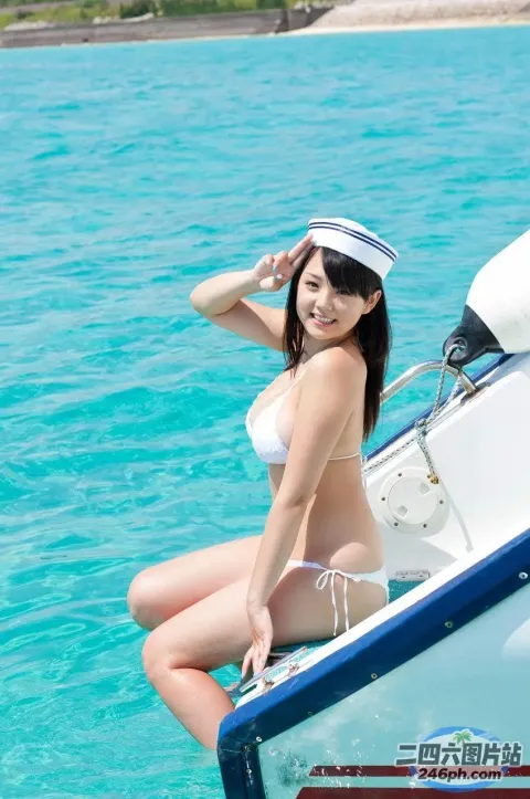 身穿白色比基尼的女人坐在海洋中的船上