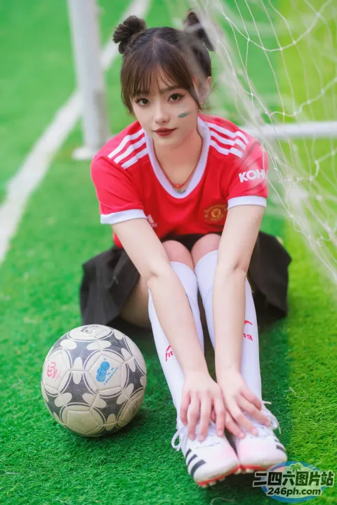 拿着足球坐在地上的阿拉菲女孩