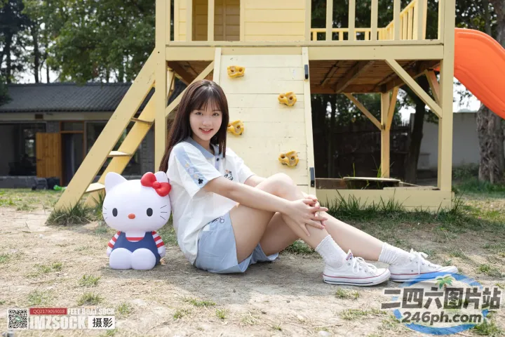 地上坐着一个女人，手里拿着一个 Hello Kitty 玩偶