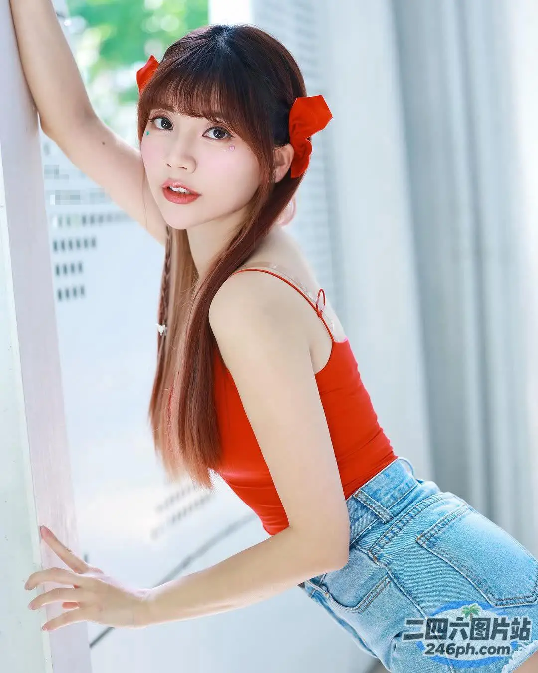一个女人靠在墙上的特写，上面穿着红色上衣