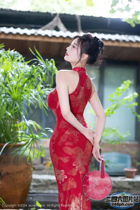 一名身穿红色连衣裙的女子正在摆姿势拍照
