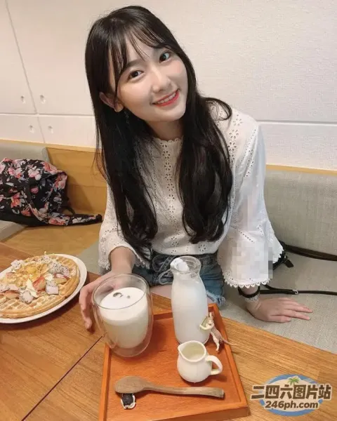 阿拉菲女人坐在桌子旁，手里拿着一盘食物和一杯牛奶