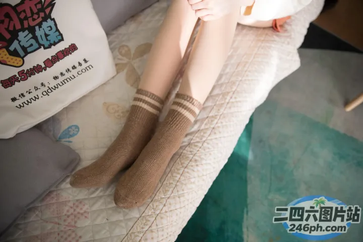 有一个女人坐在床上，双腿交叉