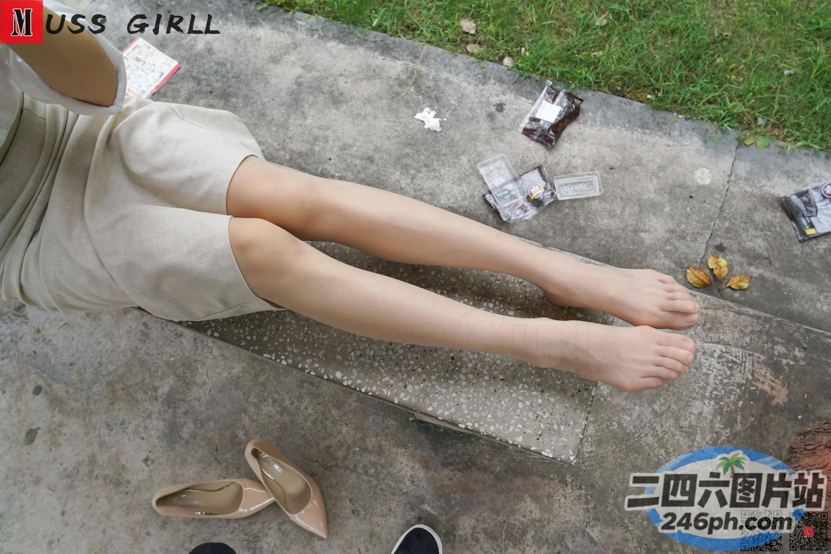 有个女人坐在水泥长凳上，双脚抬起