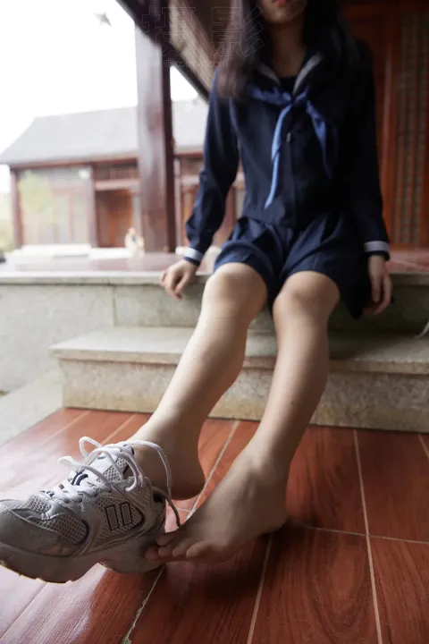 有一个女人坐在台阶上，双脚抬起