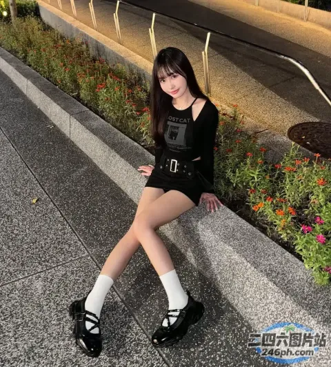 阿拉菲穿着黑色连衣裙和白色袜子坐在窗台上