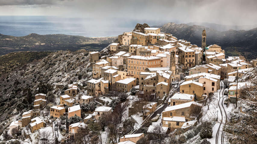 白雪皑皑的山上的 Arafed 村庄，背景是尖塔