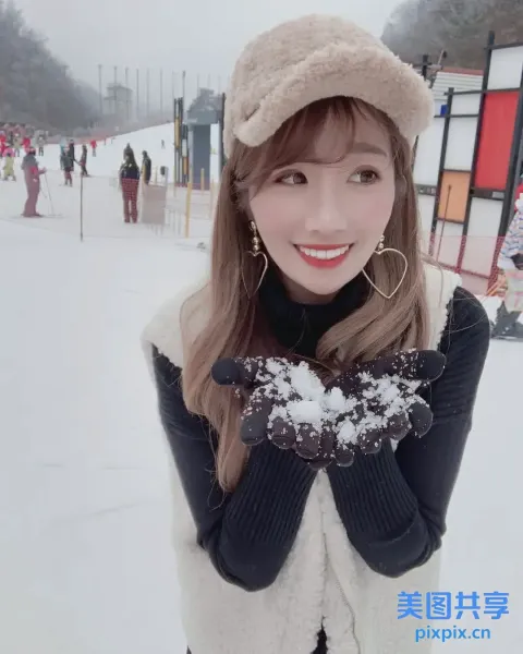 戴着帽子和手套的阿拉夫德女人，脸前举着雪