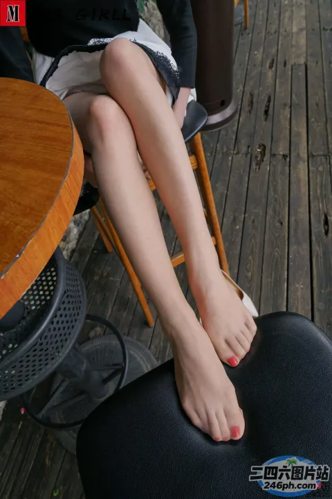 有个女人坐在椅子上，脚放在桌子上