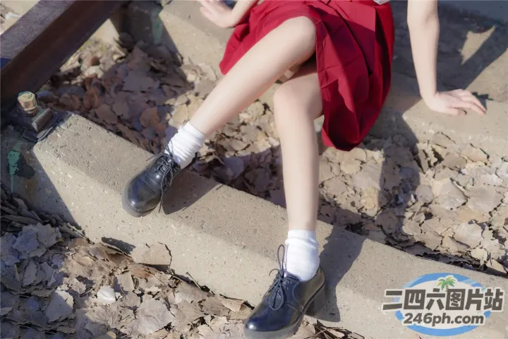 有一个女人坐在台阶上，双腿交叉
