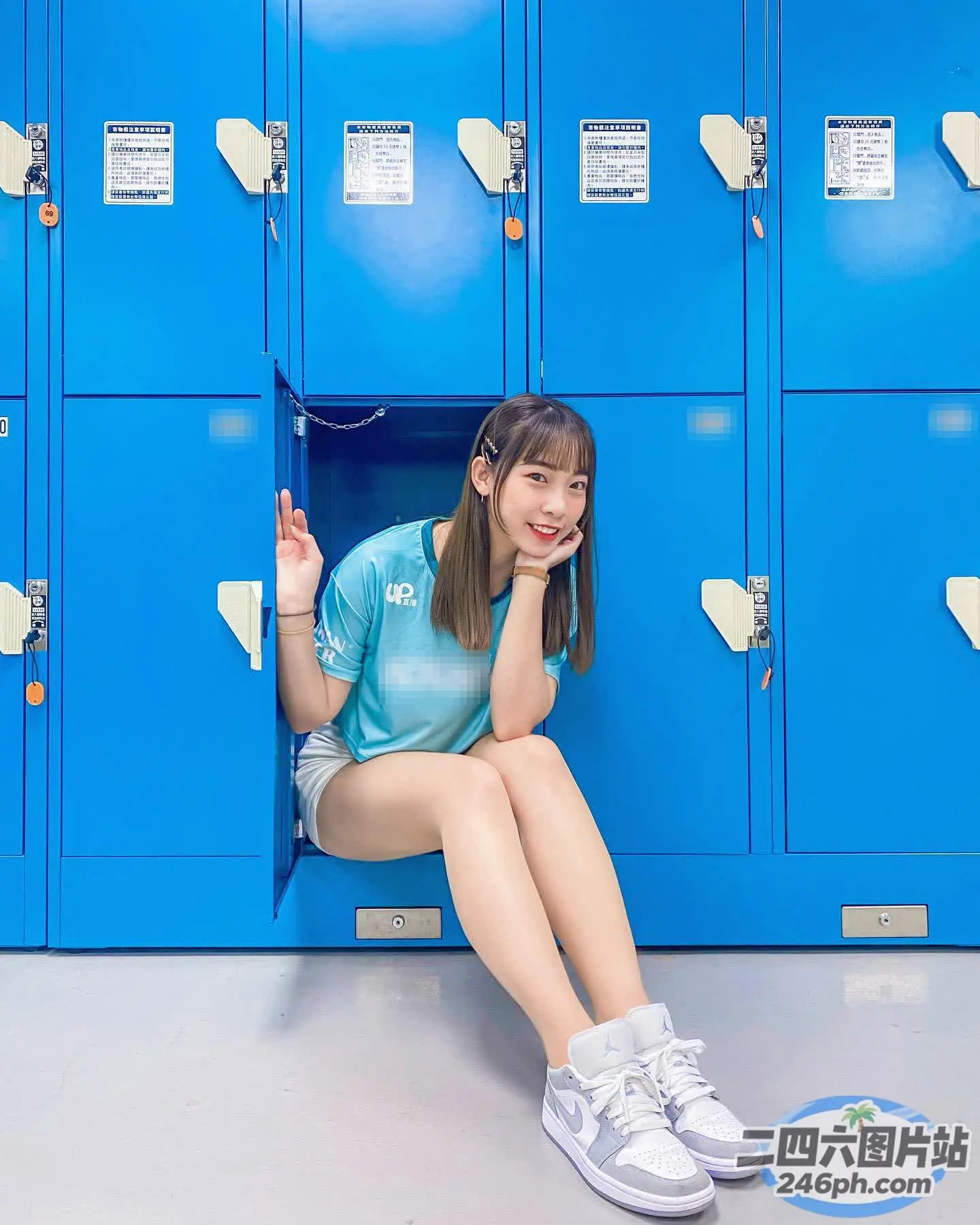 阿拉菲女孩坐在储物柜里，身后有一个蓝色的储物柜