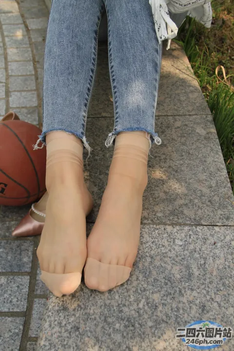 人行道上放着篮球的 Araffed Feet 和一个女人的脚