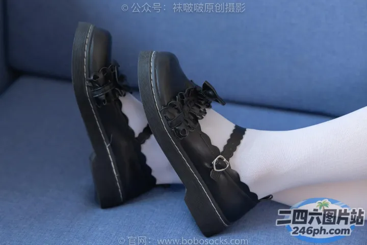 蓝色沙发上坐着一个穿着黑色鞋子和白色袜子的女人
