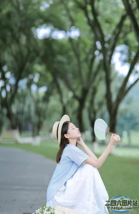 戴着帽子，拿着镜子坐在地上的女人