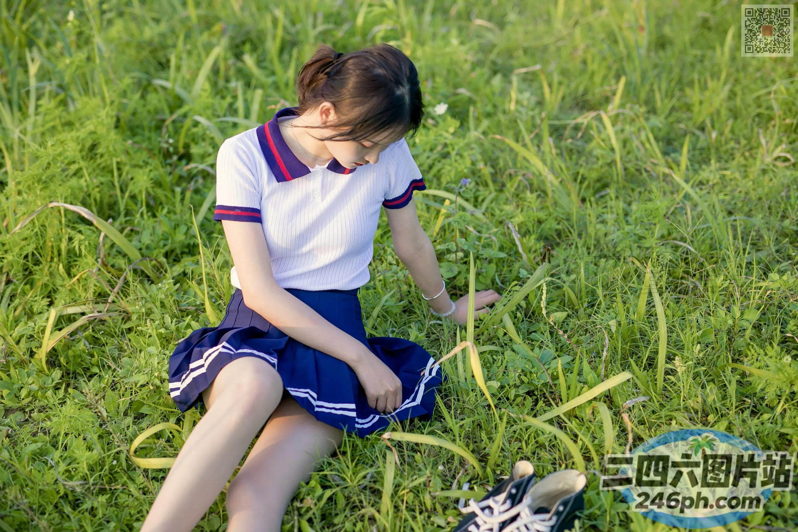 穿着鞋子坐在草地上的阿拉菲德女孩