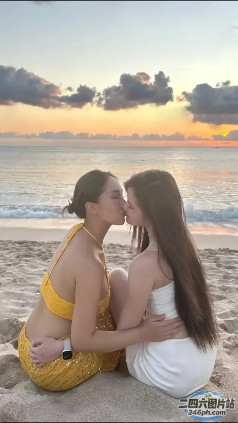 两个女人坐在海滩上互相亲吻