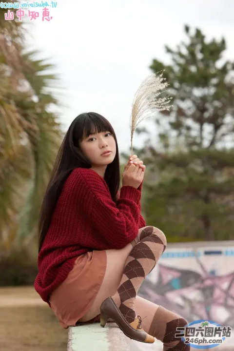 一个女人坐在窗台上拿着一瓶啤酒的特写