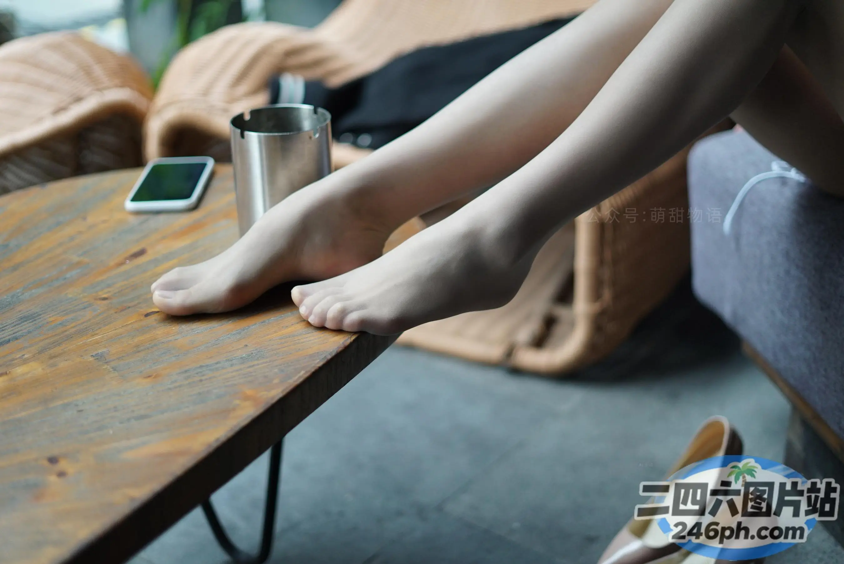 有人坐在沙发上，双脚放在桌子上