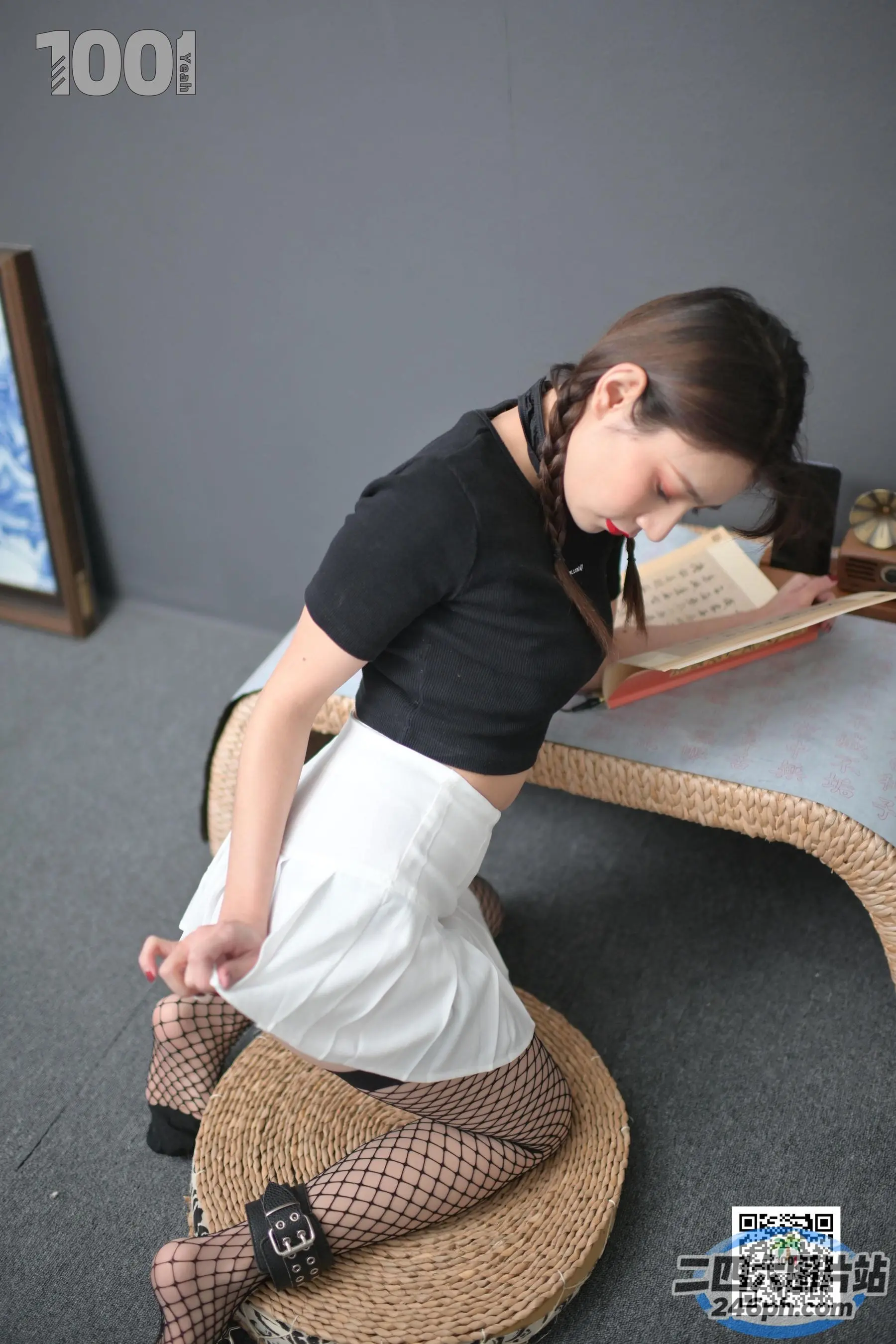 有个女人坐在椅子上，手里拿着一本书