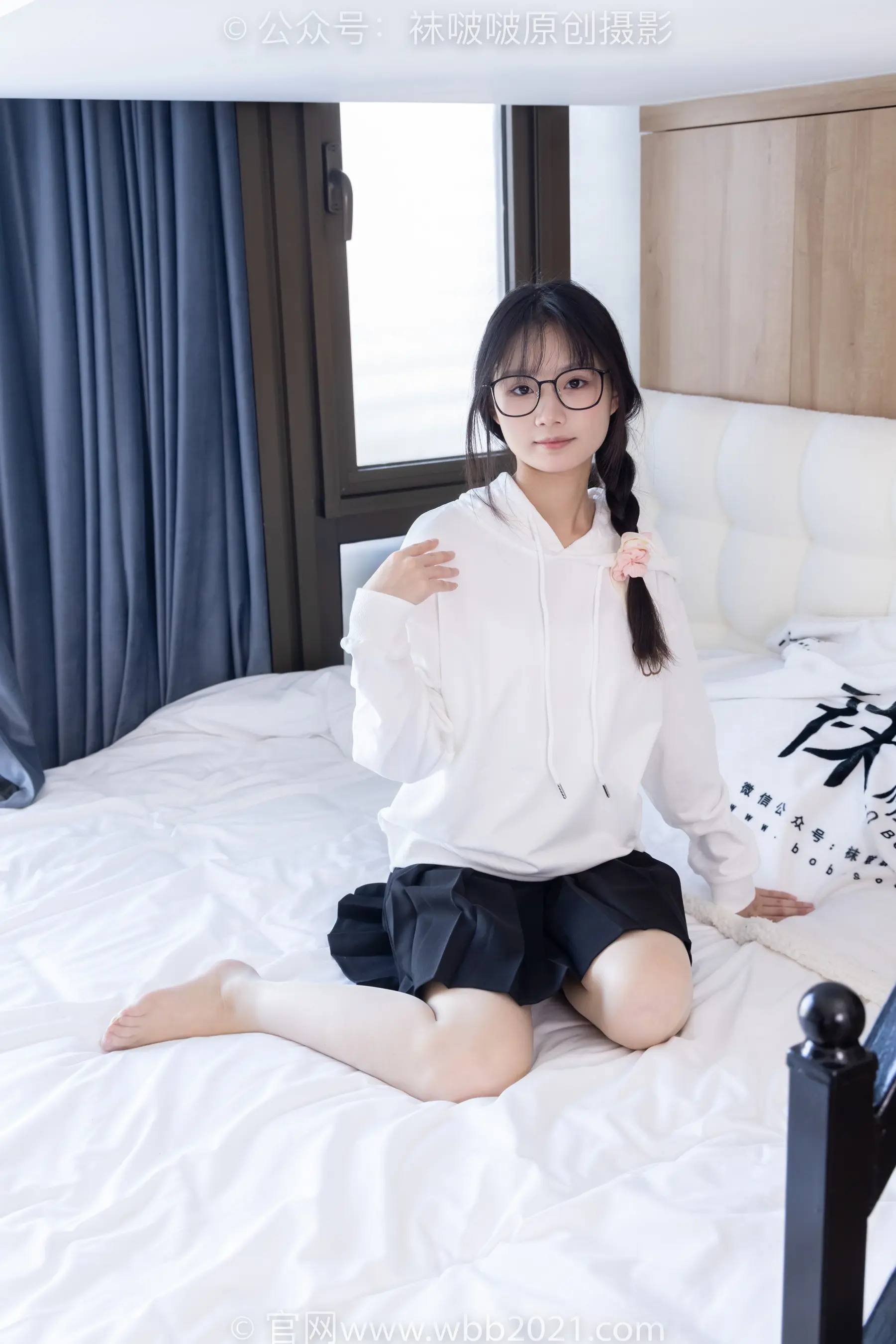 穿着白衬衫和黑色裙子坐在床上的阿拉夫德亚裔女子