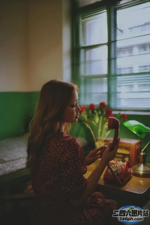 有个女人坐在桌子旁，手里拿着电话