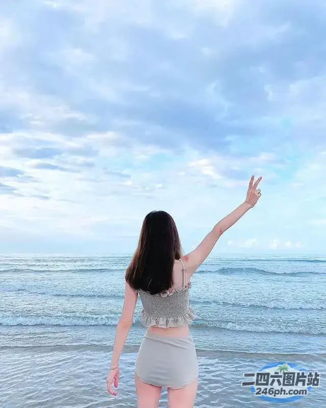 站在海滩上，双臂伸向空中的女人