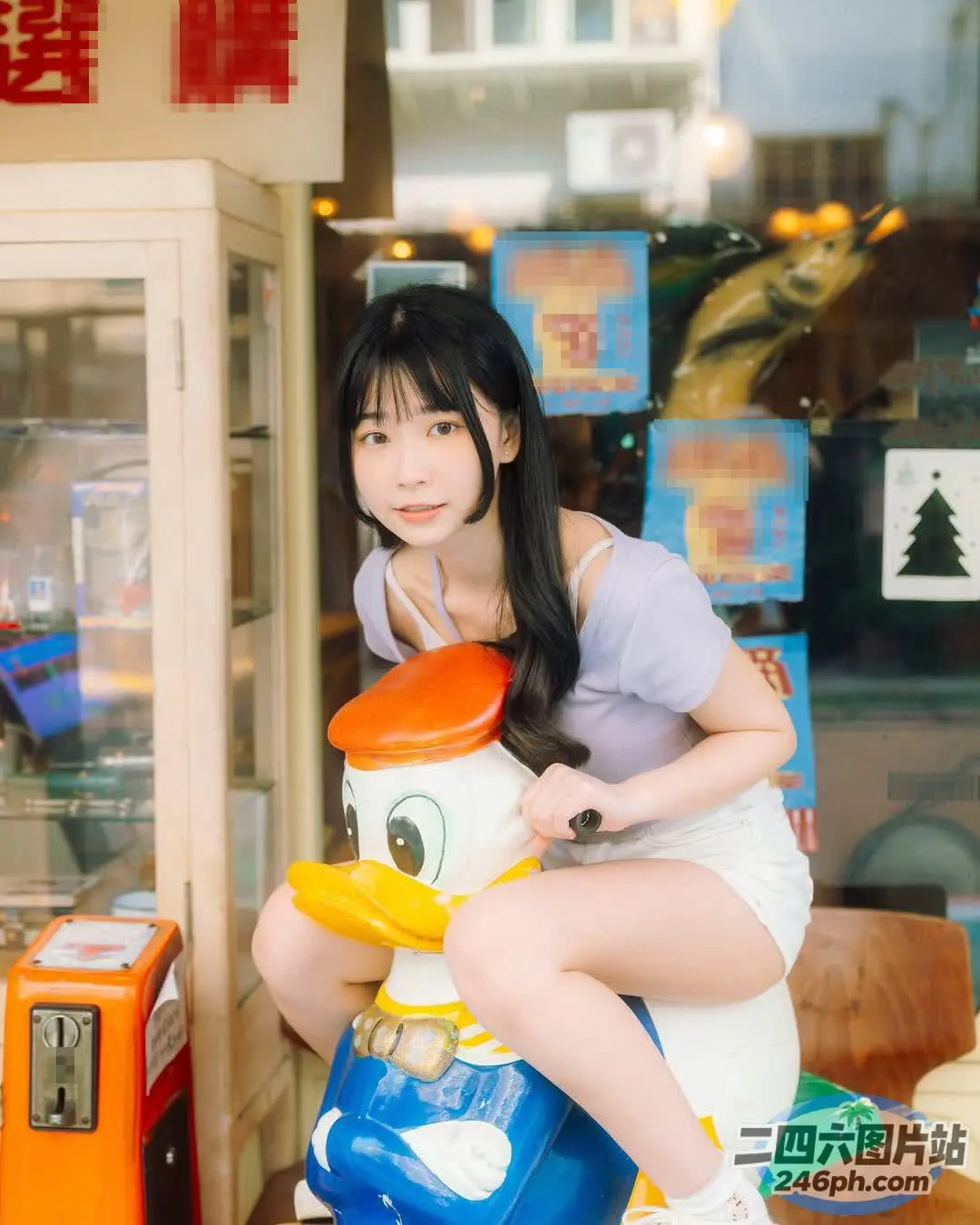 店门口有个女人坐在一只玩具鸭子上