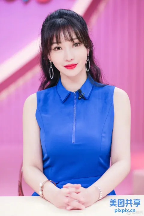 一个穿着蓝色连衣裙的女人坐在桌子旁的特写