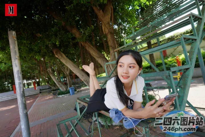 有个女人坐在长凳上，手里拿着手机