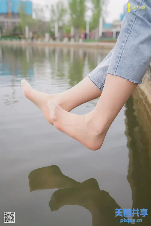有一个人坐在水边的壁架上