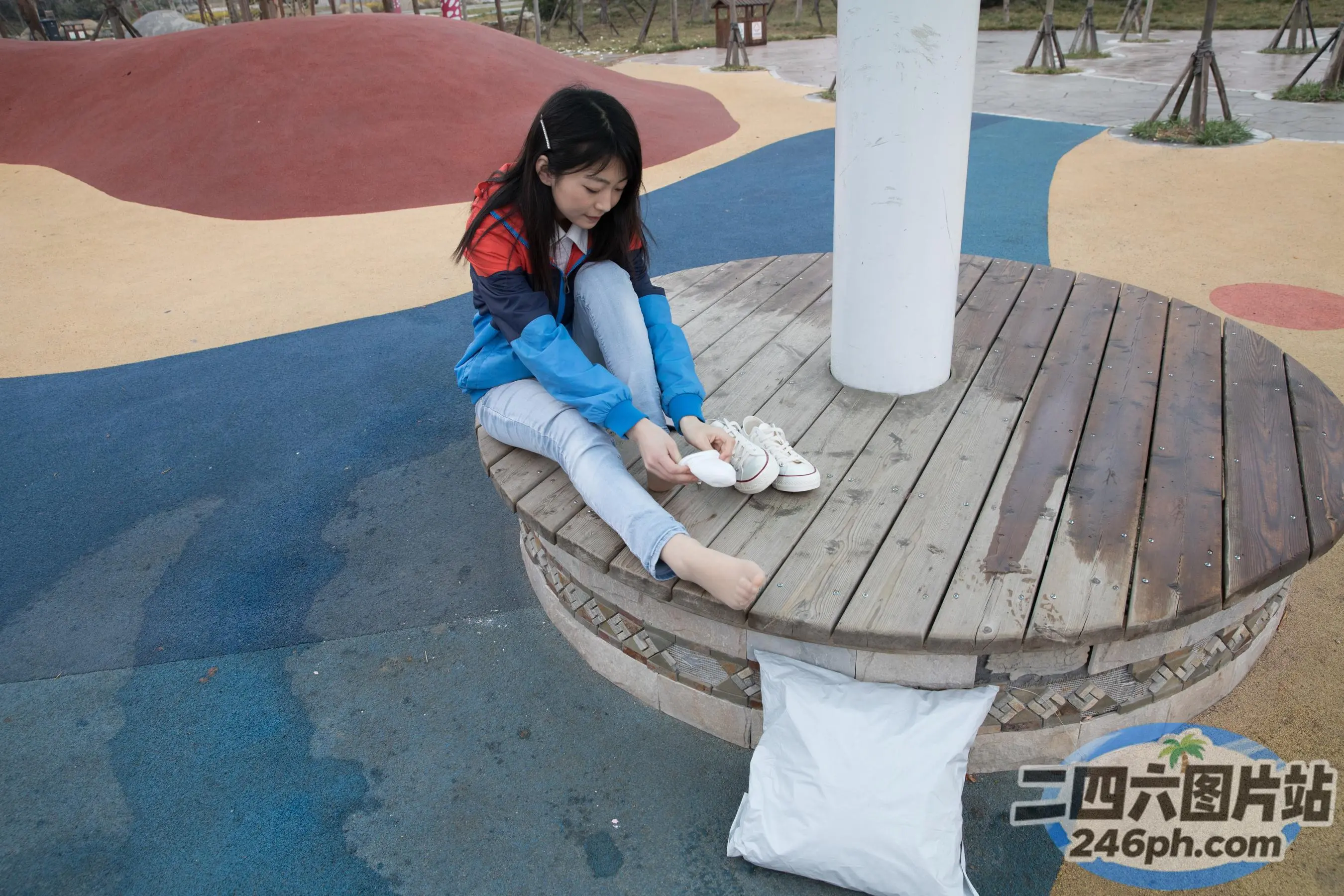 公园的长椅上坐着一个年轻女孩