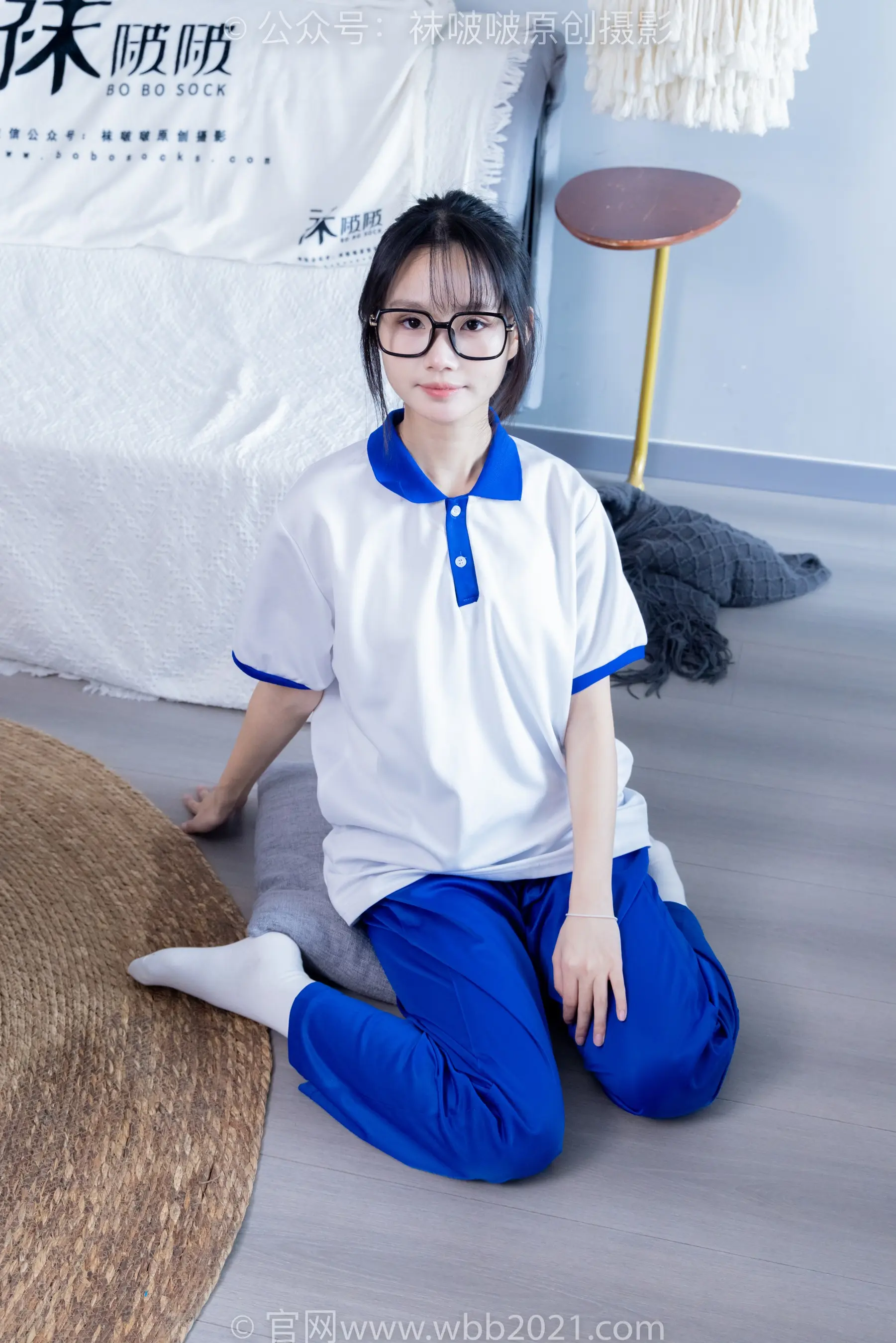 穿着白衬衫和蓝色裤子坐在地板上的 arafed 亚裔女子