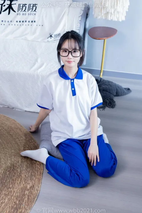 穿着白衬衫和蓝色裤子坐在地板上的 arafed 亚裔女子