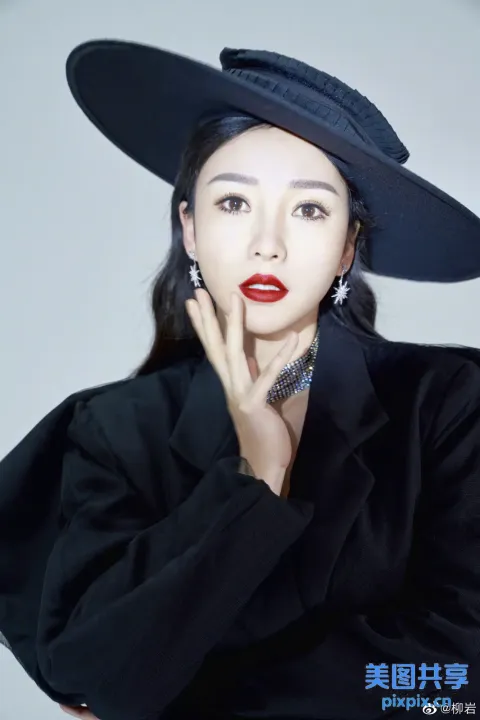 戴着黑色帽子和黑色外套的阿拉夫女子摆姿势拍照