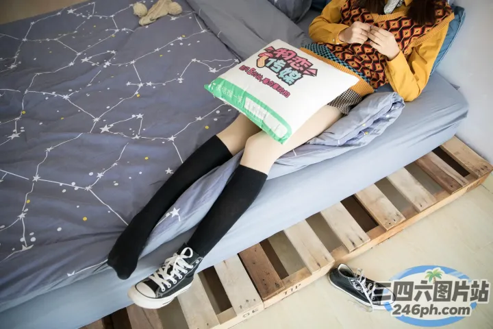 阿拉菲坐在床上，手里拿着一本书和一双鞋