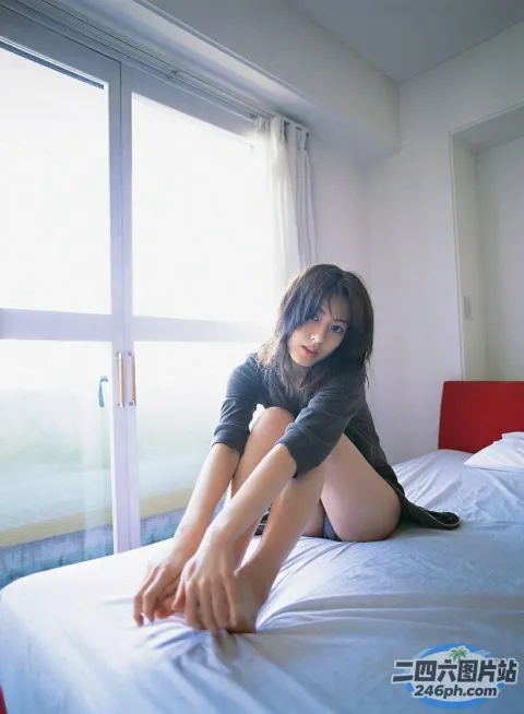 有一个女人坐在床上，双腿交叉